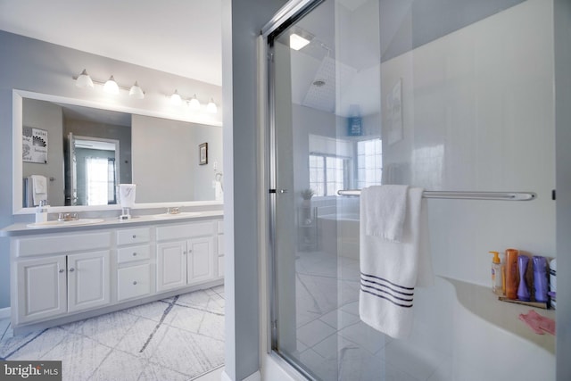 bathroom featuring a healthy amount of sunlight, a shower with door, and vanity