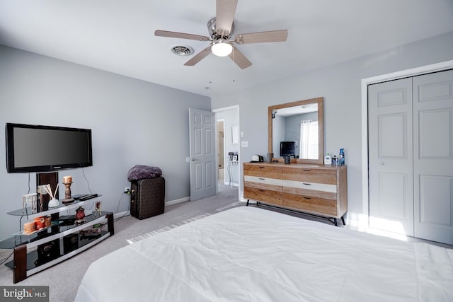 bedroom featuring ceiling fan, light colored carpet, and a closet