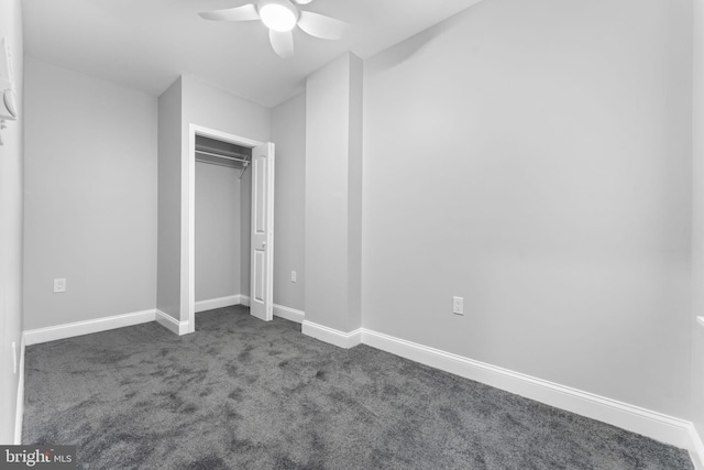 unfurnished bedroom featuring a ceiling fan, a closet, dark carpet, and baseboards