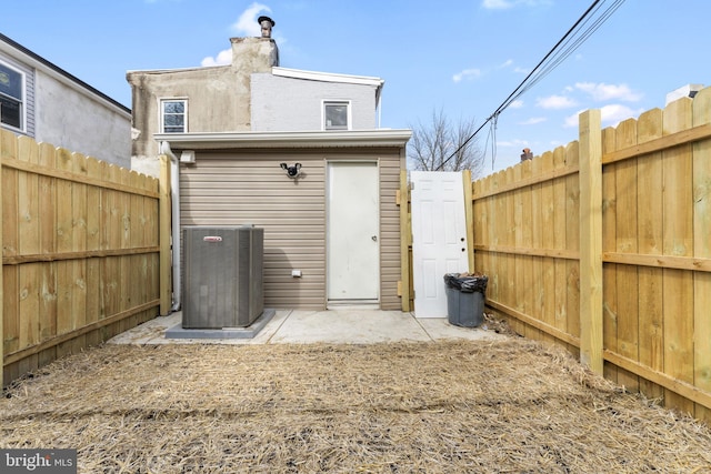 back of property featuring central air condition unit, a chimney, and fence