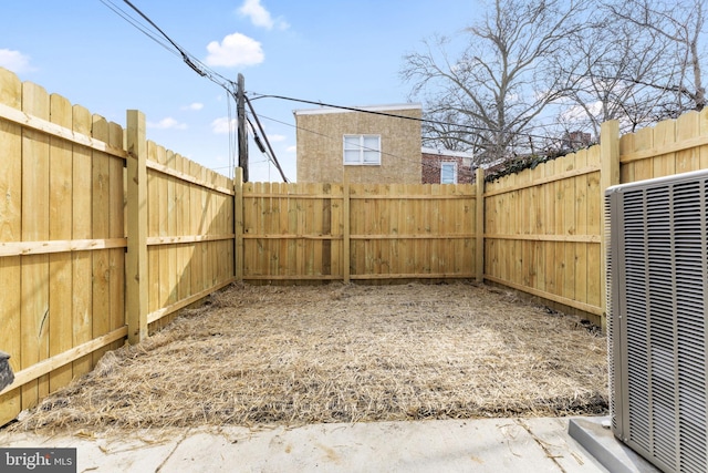 view of yard with central AC and a fenced backyard