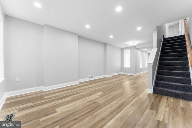 basement with recessed lighting, visible vents, light wood-type flooring, baseboards, and stairs