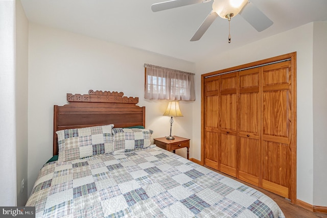 bedroom with baseboards, wood finished floors, a closet, and ceiling fan