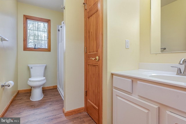 bathroom with curtained shower, baseboards, toilet, wood finished floors, and vanity