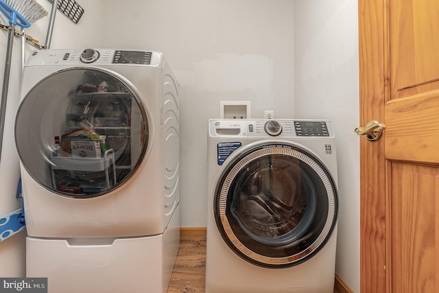 laundry room featuring independent washer and dryer, wood finished floors, and laundry area