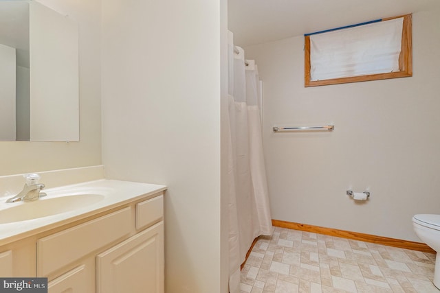 full bathroom featuring vanity, toilet, and baseboards