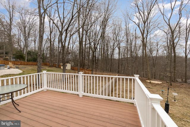 wooden terrace featuring fence, an outdoor structure, and a shed