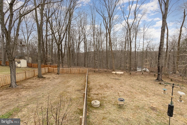 view of yard featuring an outdoor structure, fence, and a shed