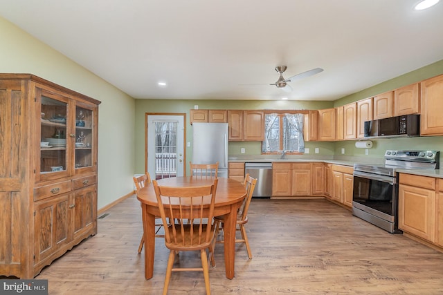 kitchen with light countertops, light wood-style flooring, appliances with stainless steel finishes, and light brown cabinetry