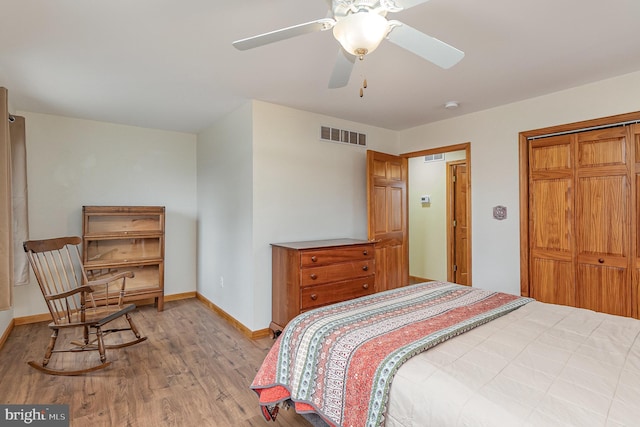 bedroom with light wood-type flooring, visible vents, a closet, baseboards, and ceiling fan