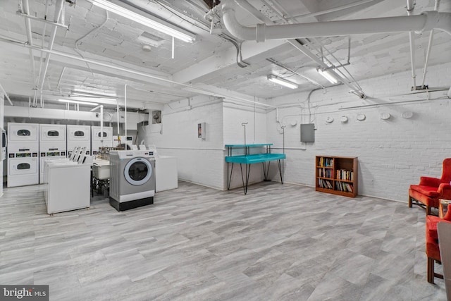 interior space with separate washer and dryer, stacked washing maching and dryer, and brick wall