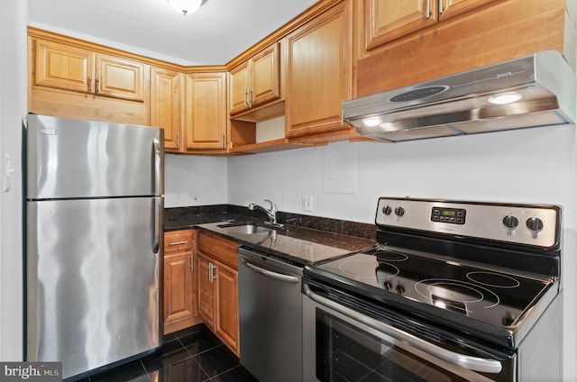 kitchen with sink, dark stone counters, and appliances with stainless steel finishes