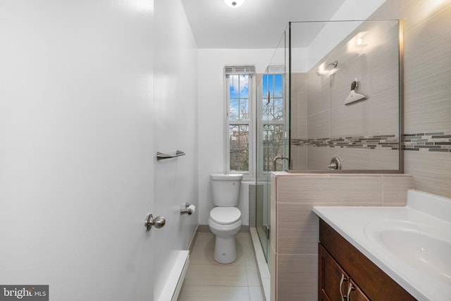 bathroom featuring a shower with door, vanity, tile patterned flooring, and toilet