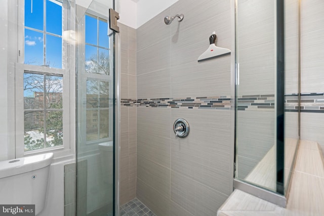 bathroom with toilet and tiled shower