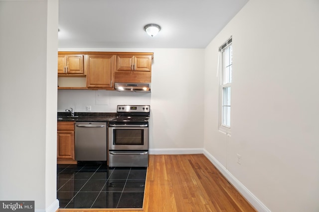 kitchen featuring dark wood-type flooring, appliances with stainless steel finishes, and sink