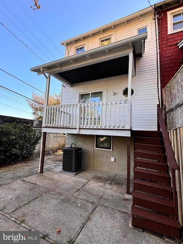 back of property with central AC and a patio