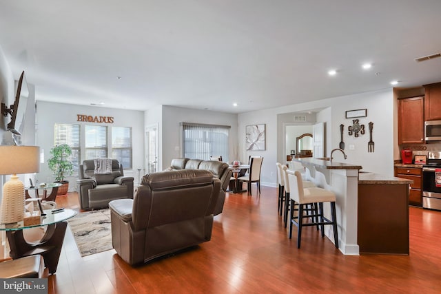 living room with sink and dark hardwood / wood-style floors