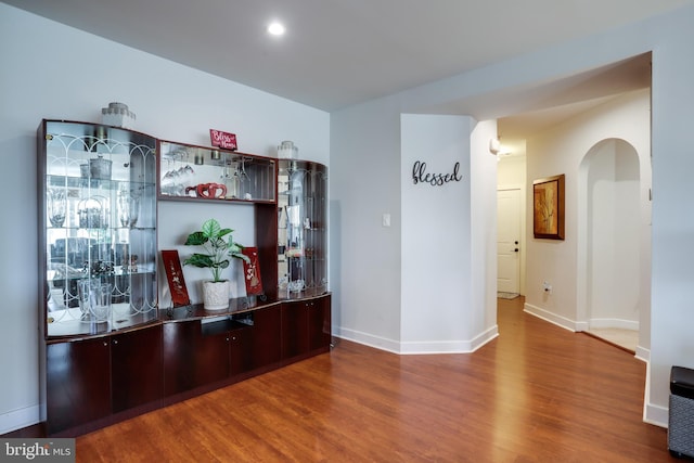 bar featuring dark brown cabinetry and hardwood / wood-style flooring