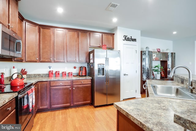 kitchen featuring sink, light wood-type flooring, and appliances with stainless steel finishes