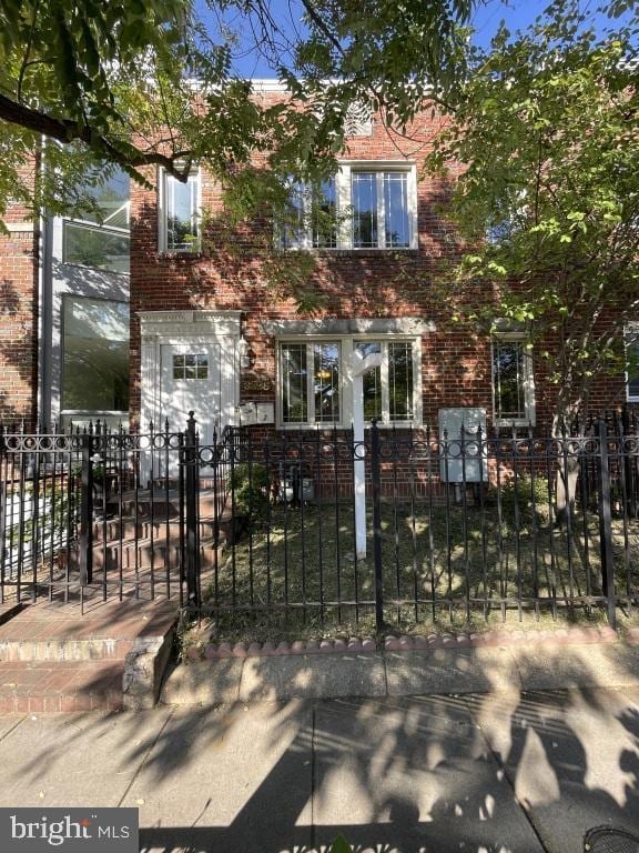 view of property with brick siding and a fenced front yard