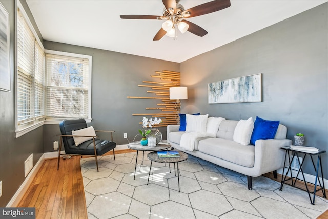 living area with baseboards, visible vents, and wood finished floors