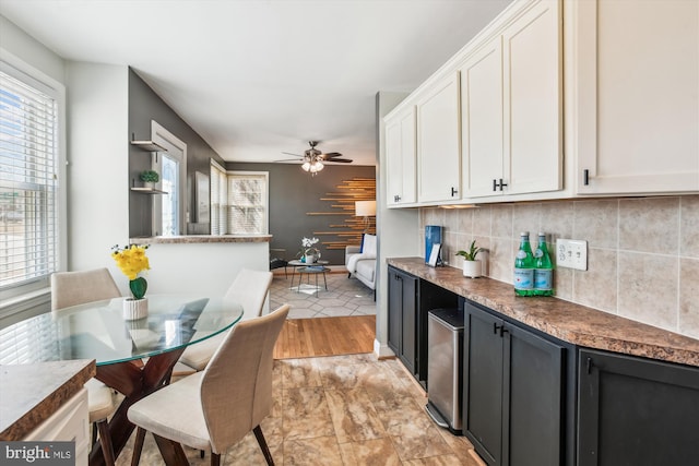 kitchen featuring white cabinets, ceiling fan, and backsplash