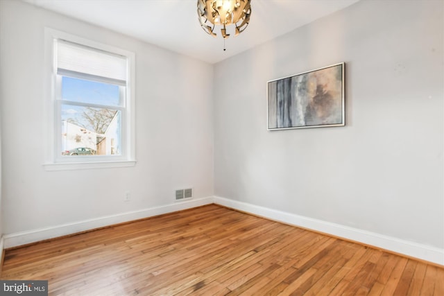 unfurnished room with light wood-style flooring, visible vents, and baseboards