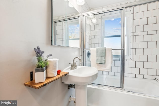 full bathroom with plenty of natural light and combined bath / shower with glass door