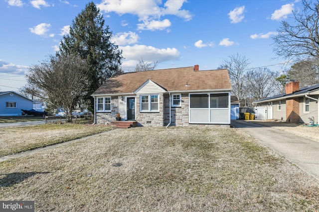 view of front facade with stone siding, aphalt driveway, a sunroom, and roof with shingles