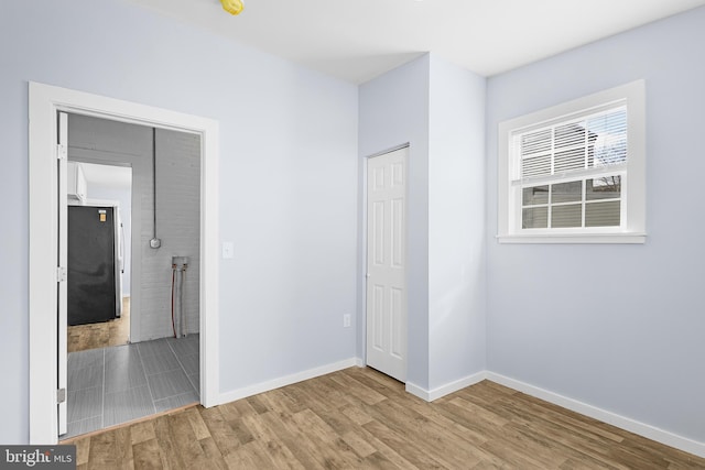 unfurnished bedroom with wood-type flooring and a closet