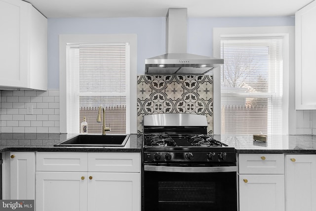 kitchen with sink, white cabinetry, black range with gas stovetop, dark stone counters, and wall chimney range hood