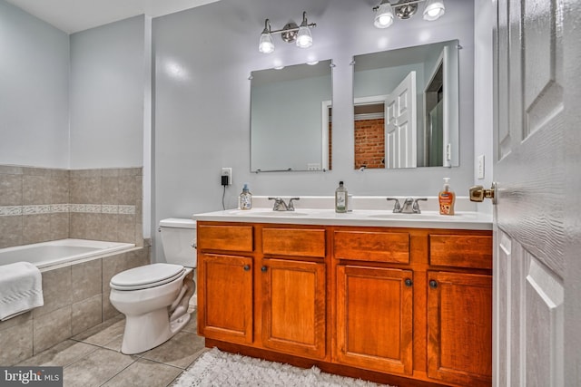 bathroom with tile patterned floors, toilet, vanity, and tiled tub