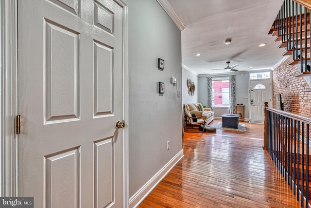 hallway with crown molding and light hardwood / wood-style flooring