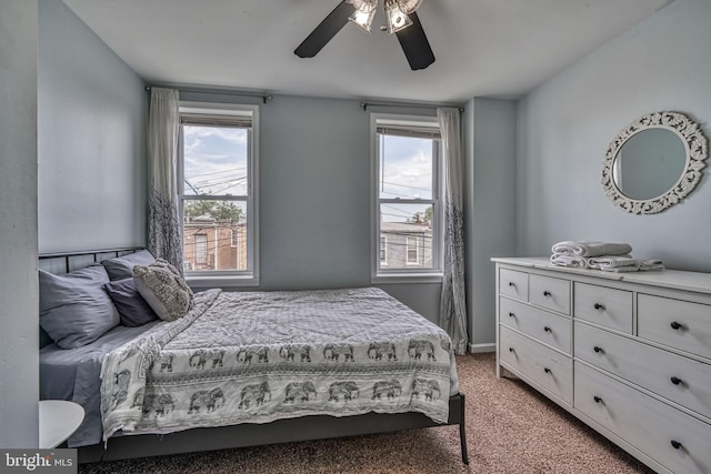 carpeted bedroom featuring multiple windows and ceiling fan