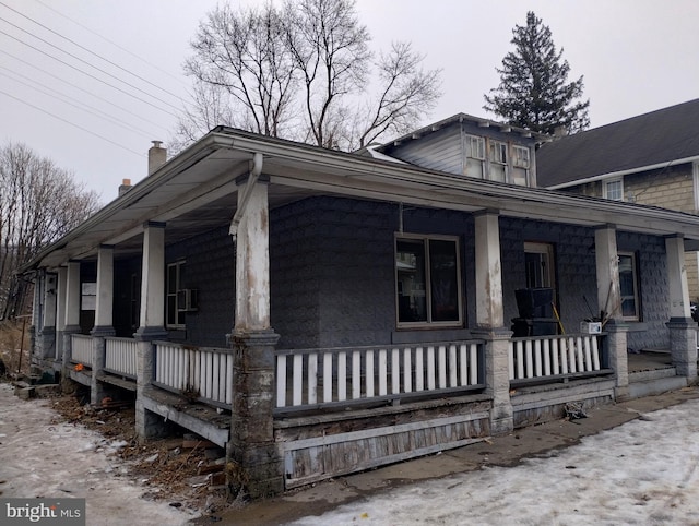 view of side of property featuring covered porch