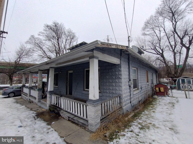 view of snow covered exterior featuring covered porch