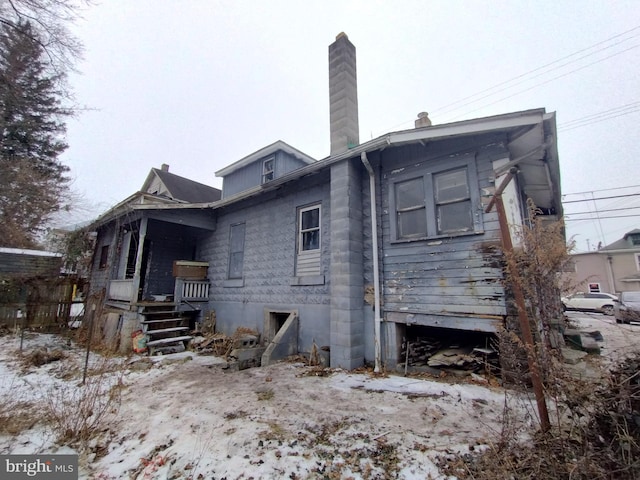 view of snow covered rear of property