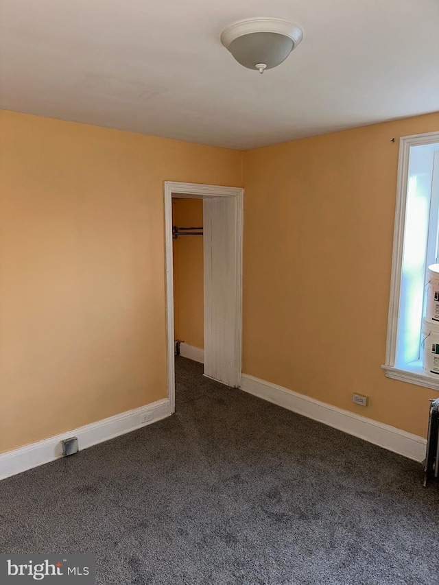 unfurnished bedroom featuring dark carpet