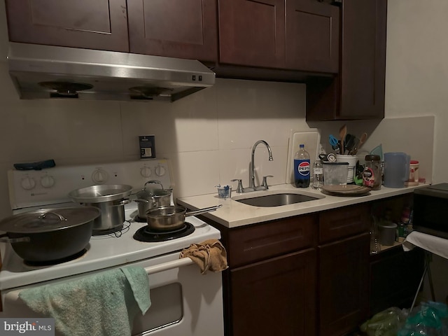 kitchen featuring dark brown cabinets, sink, backsplash, and white range with electric cooktop