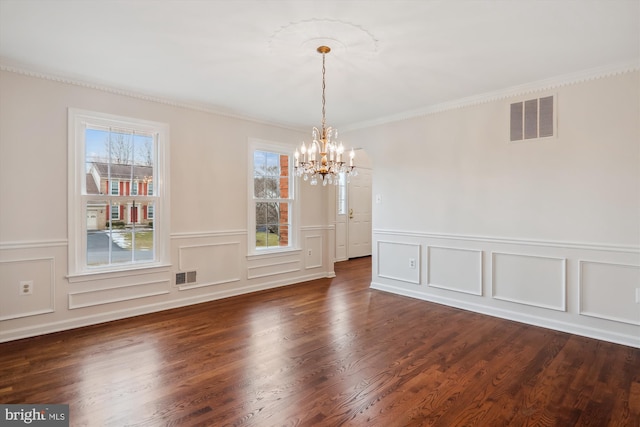 unfurnished dining area with dark hardwood / wood-style flooring, ornamental molding, and an inviting chandelier