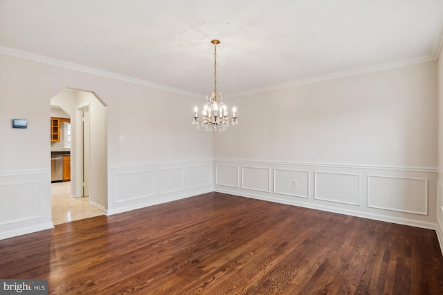 unfurnished room with an inviting chandelier, hardwood / wood-style floors, and ornamental molding