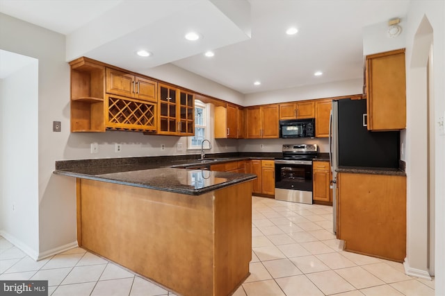 kitchen featuring stainless steel range with electric stovetop, kitchen peninsula, dark stone countertops, and light tile patterned flooring