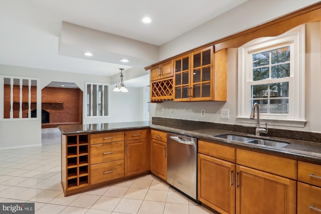 kitchen featuring dishwasher, sink, hanging light fixtures, light tile patterned floors, and kitchen peninsula