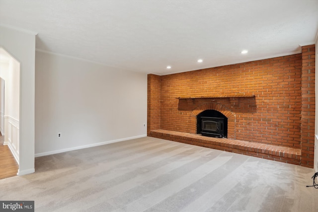 unfurnished living room featuring crown molding, light colored carpet, and brick wall