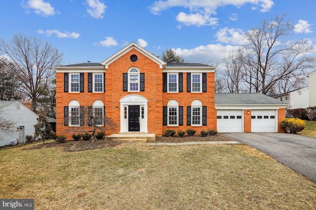 colonial inspired home with a garage and a front yard