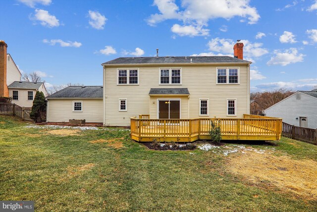 back of property featuring a wooden deck and a lawn