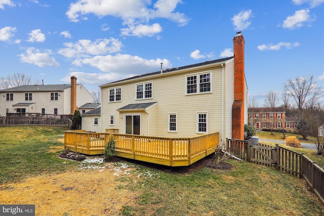 back of house featuring a wooden deck and a yard