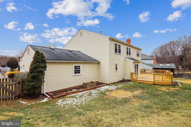 back of house featuring a wooden deck and a yard