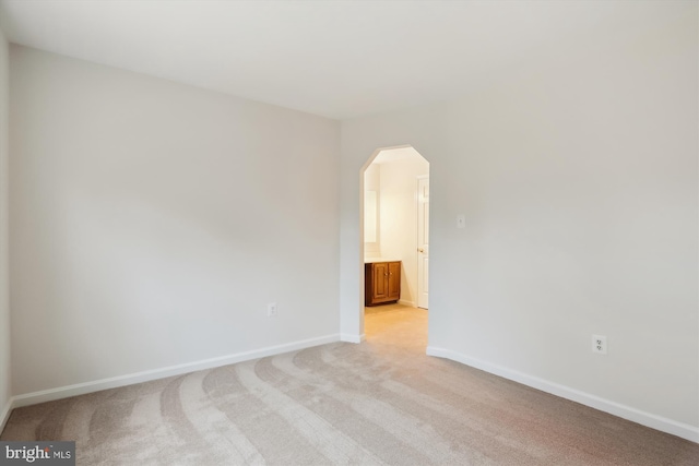 spare room featuring light colored carpet