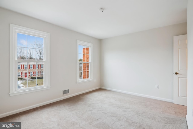 spare room featuring light colored carpet